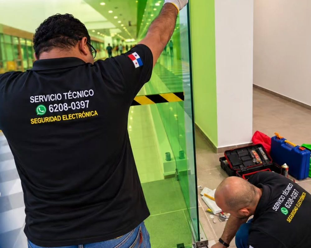 Técnicos cambiando el cierra puertas de una puerta de vidrio